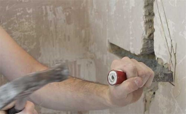 Shtroblenie væg med en hammer og mejsel