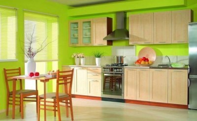 Kombinationen af ​​lysegrøn farve i det indre af køkkenet med kontrasterende røde detaljer